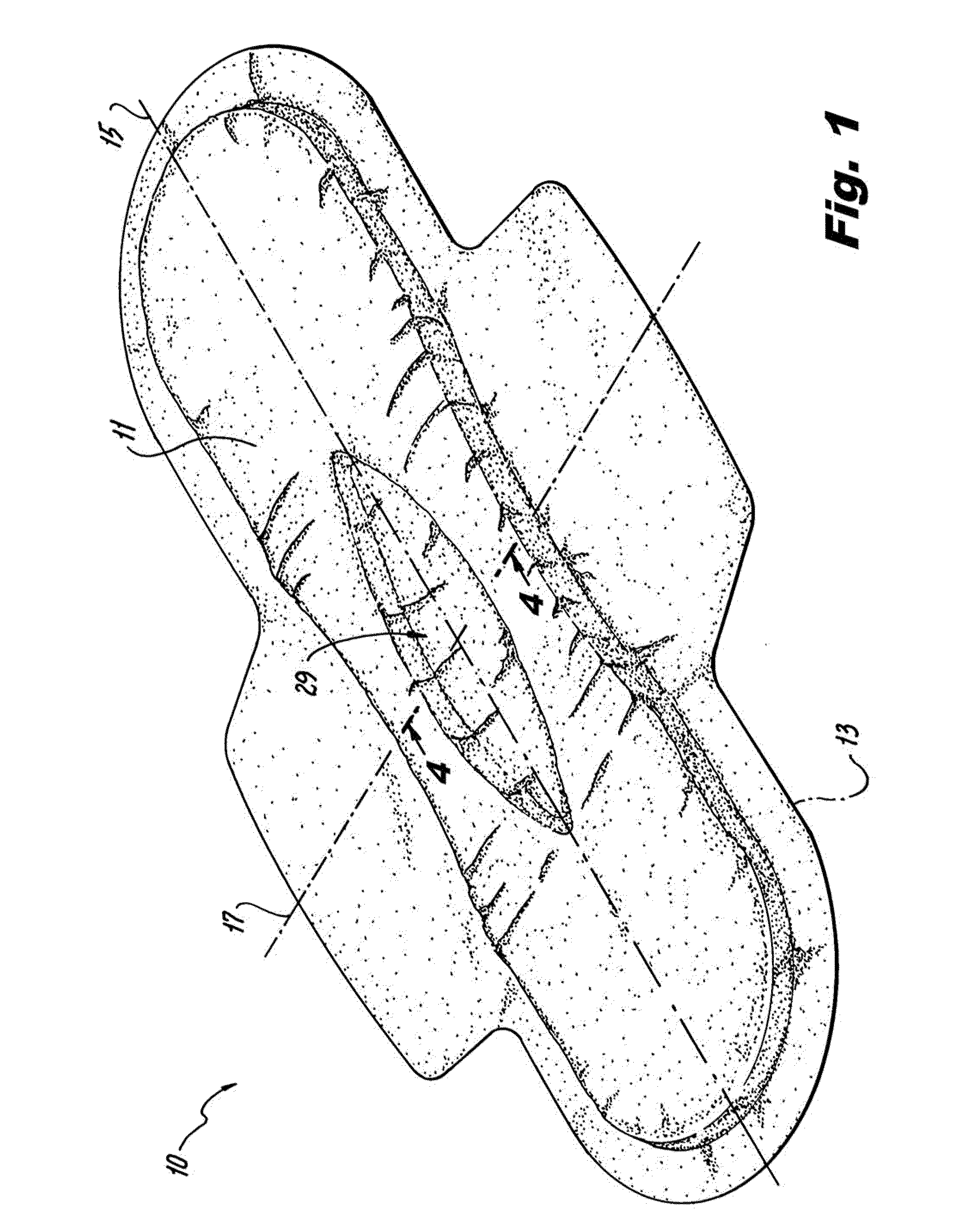 Absorbent article including an absorbent core layer having a material free zone and a transfer layer arranged below the absorbent core layer